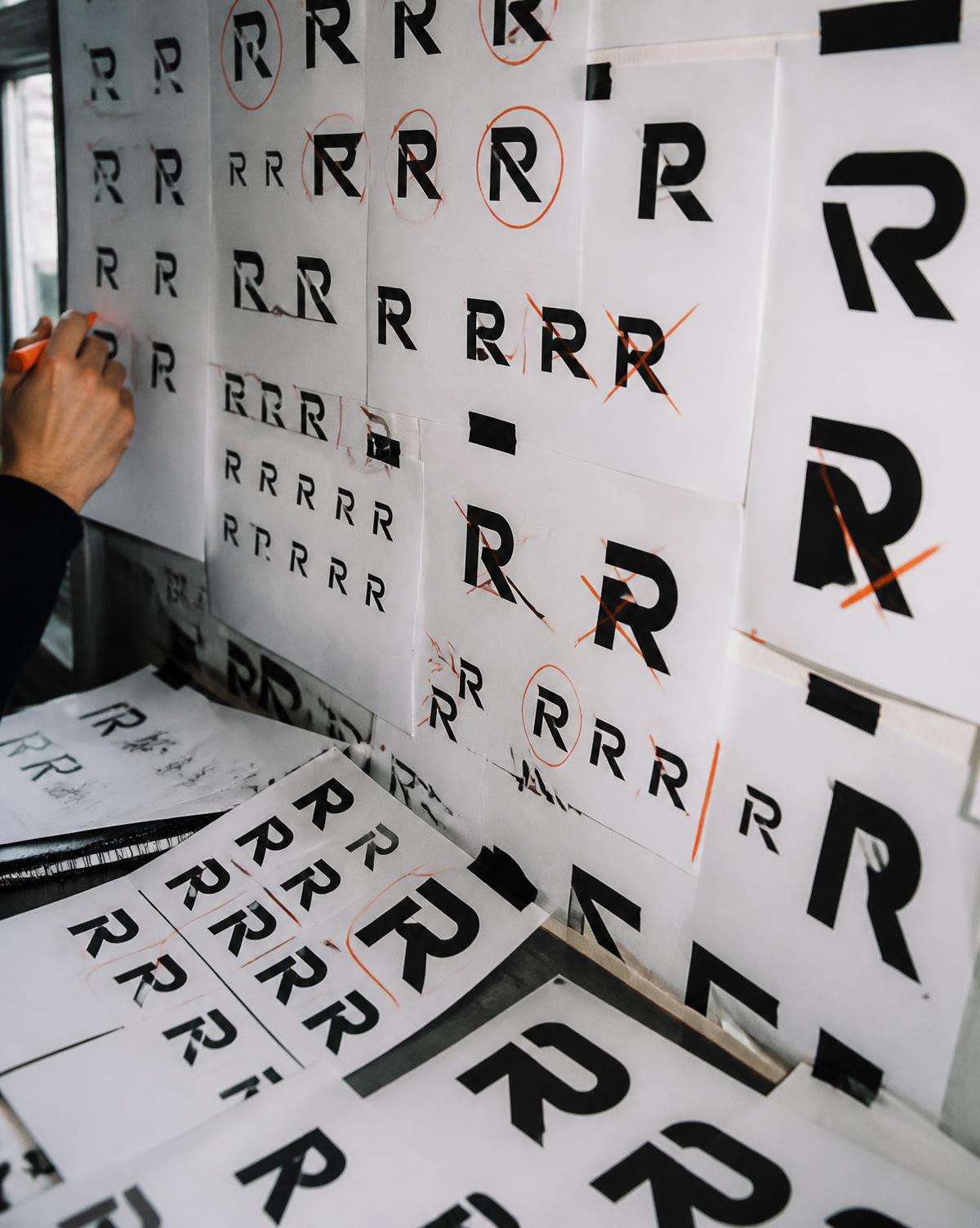 Enlarged letterform tests pinned to the wall during identity development