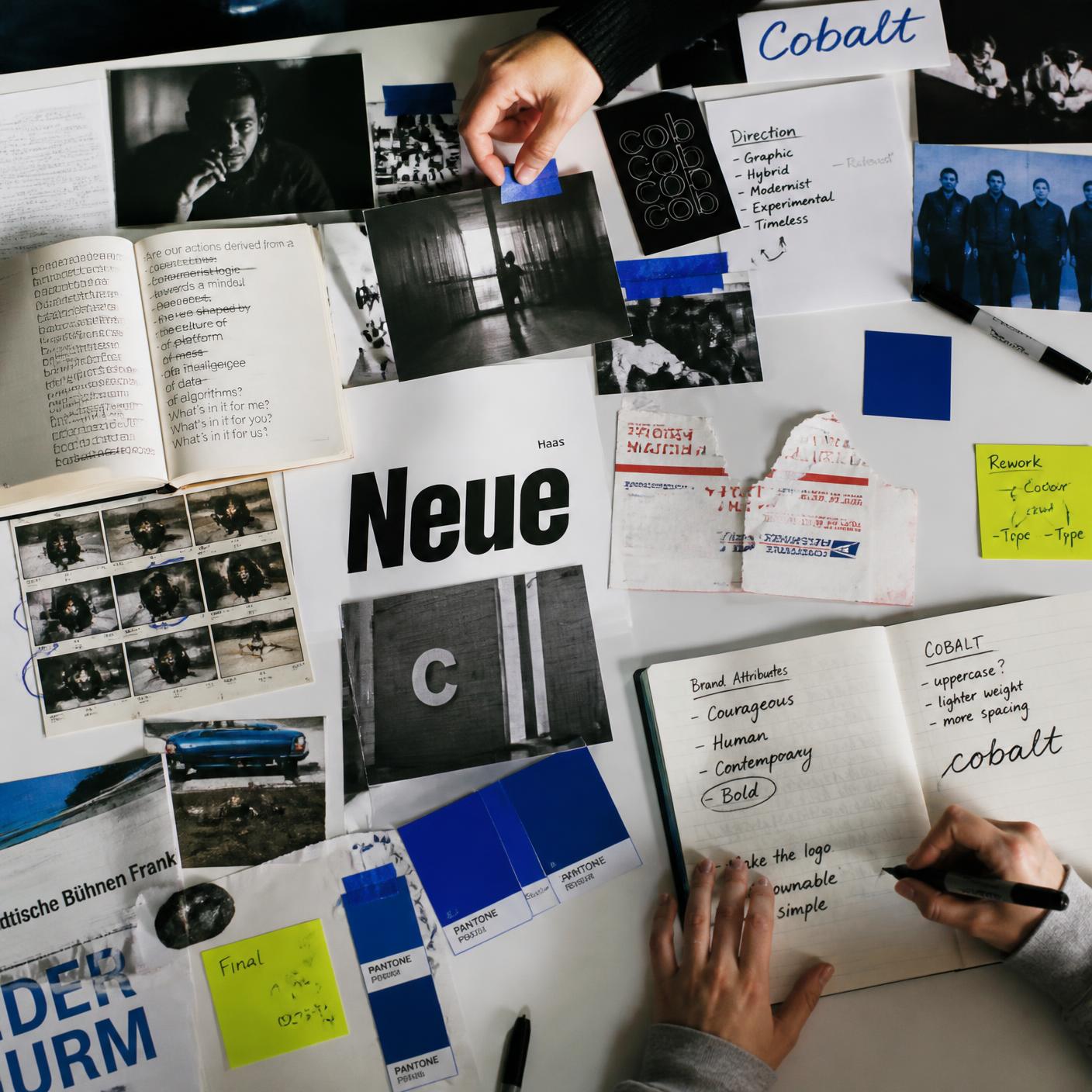 Overhead view of a research table: printed references compared side by side with cobalt swatches and handwritten notes